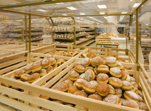 Doughnuts and bread on shelves in bakery store
